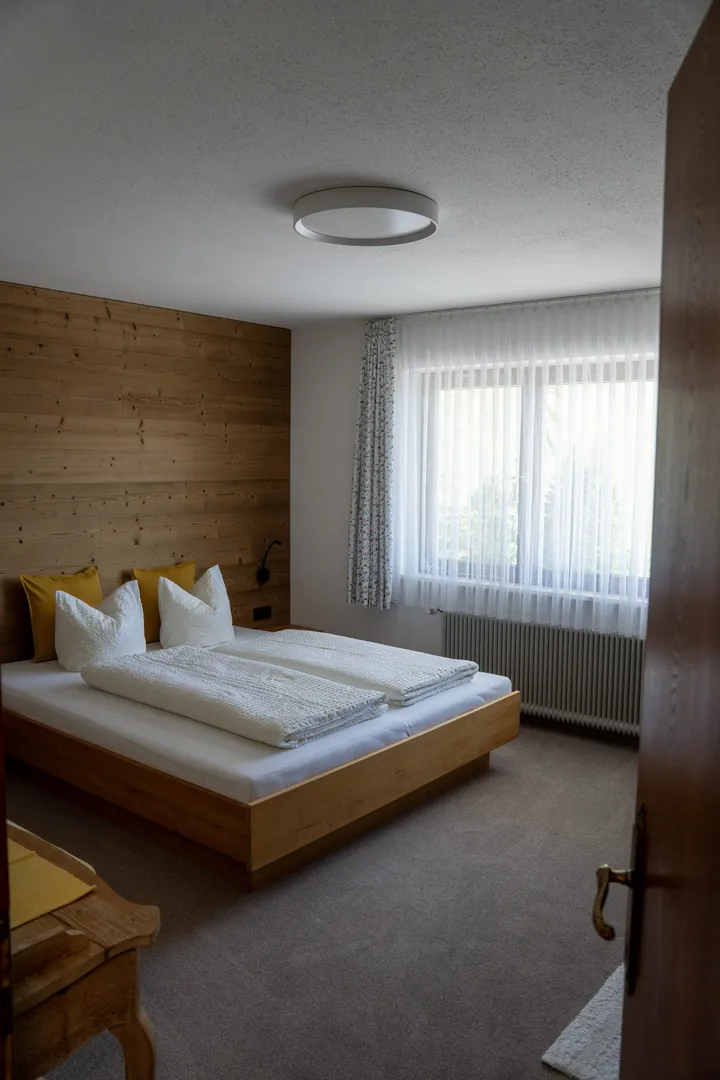 Schlafzimmer mit großem Fenster und Doppelbett