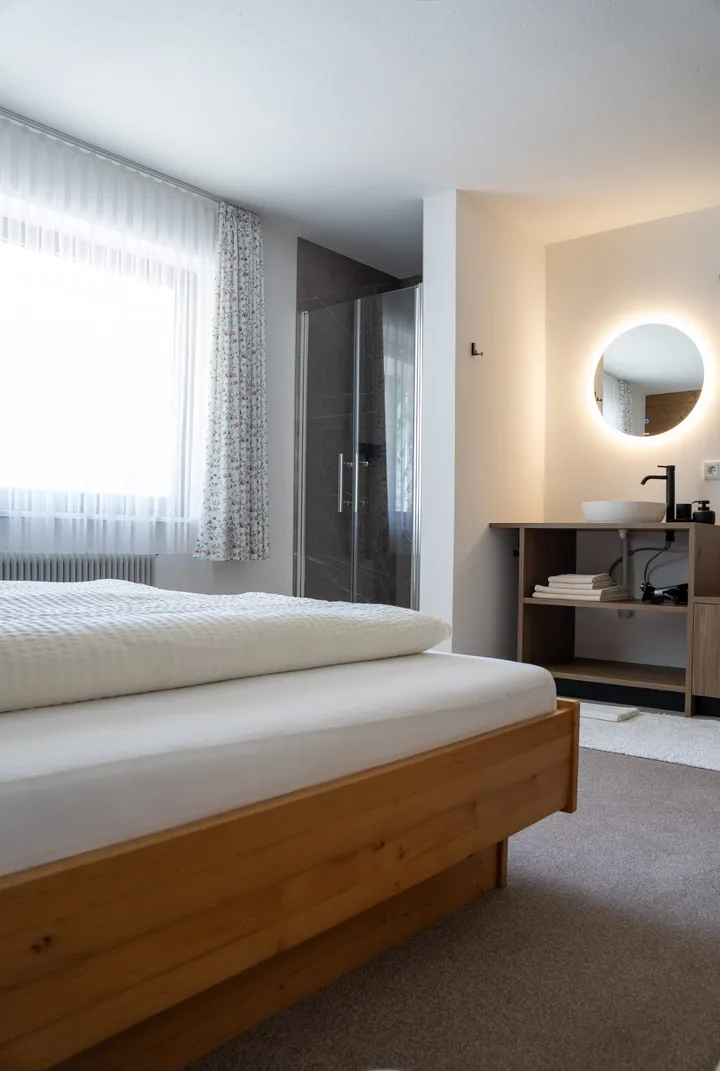 Doppelbett mit Waschbecken und beleuchtetem Spiegel