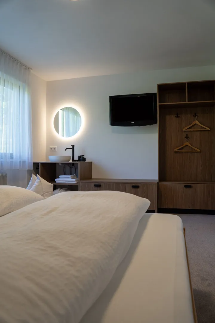 Schlafzimmer mit Waschtisch und Fernseher
