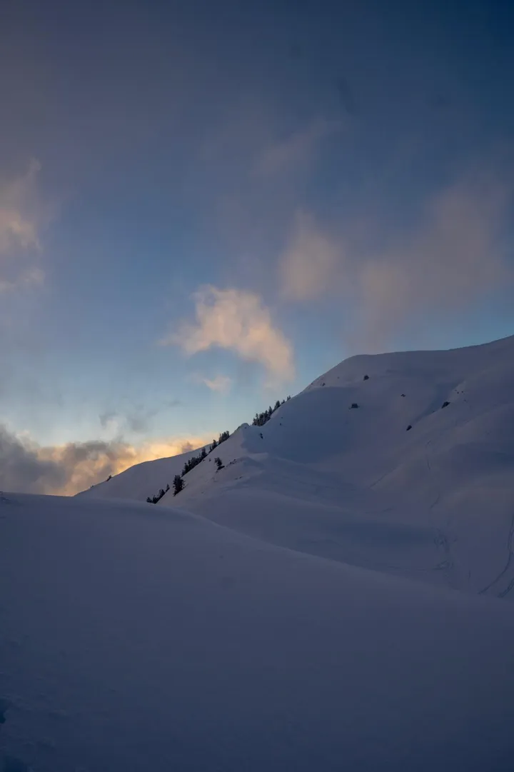 Verschneiter Hang in der Abenddämmerung